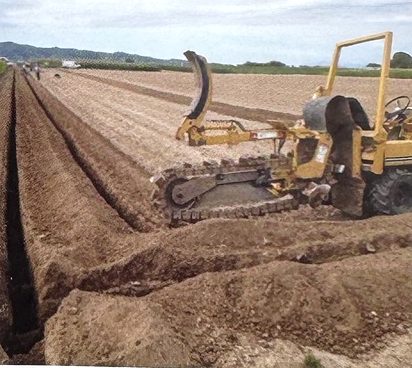 Grabenfräse beim Leitungsgraben im Feld